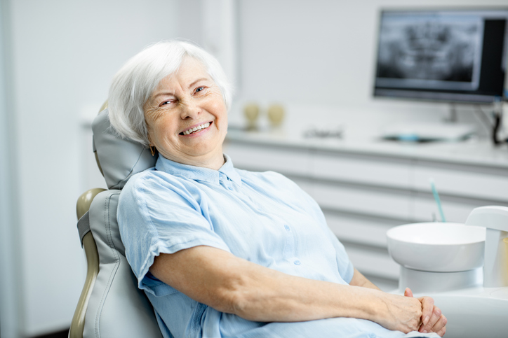 Senior woman at the periodontist office after dental implant treatment.